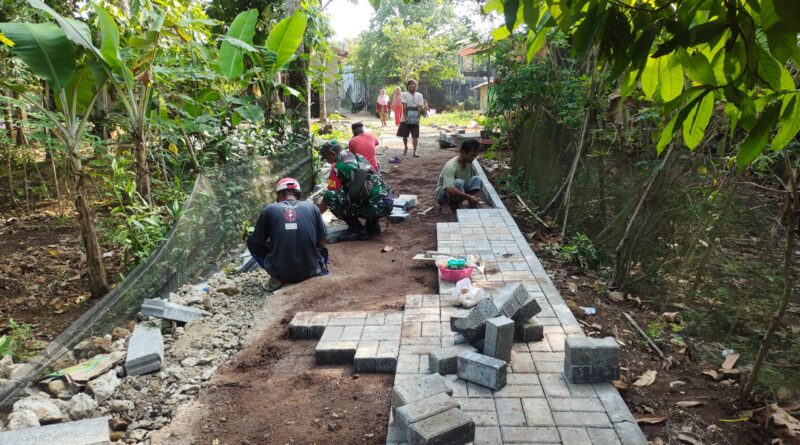 Kegiatan Gotong Royong Babinsa Pandeglang, Kopka Tata Suardi Bantu Pemasangan Paving Blok di Desa Purwaraja